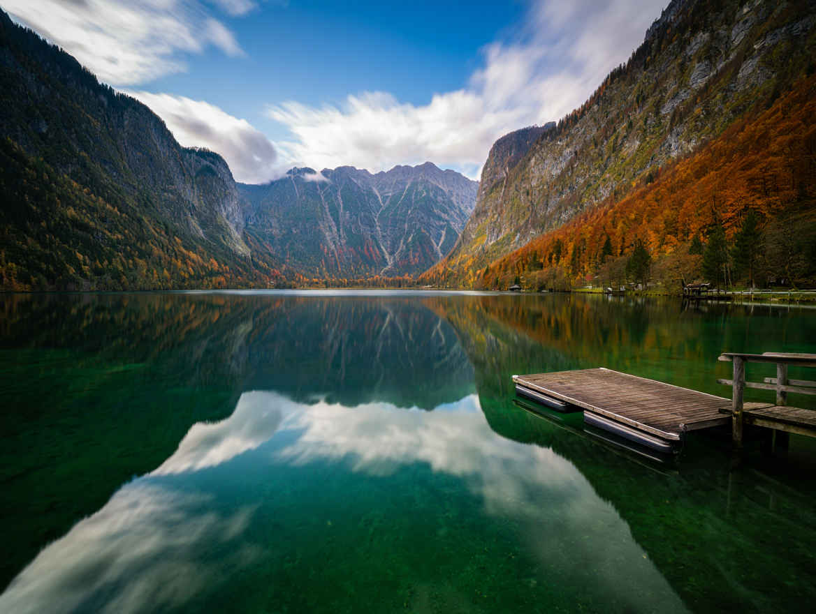Blick auf den Königssee in Bayern mit spiegelklarem Wasser und steilen Bergwänden im Herbstlicht